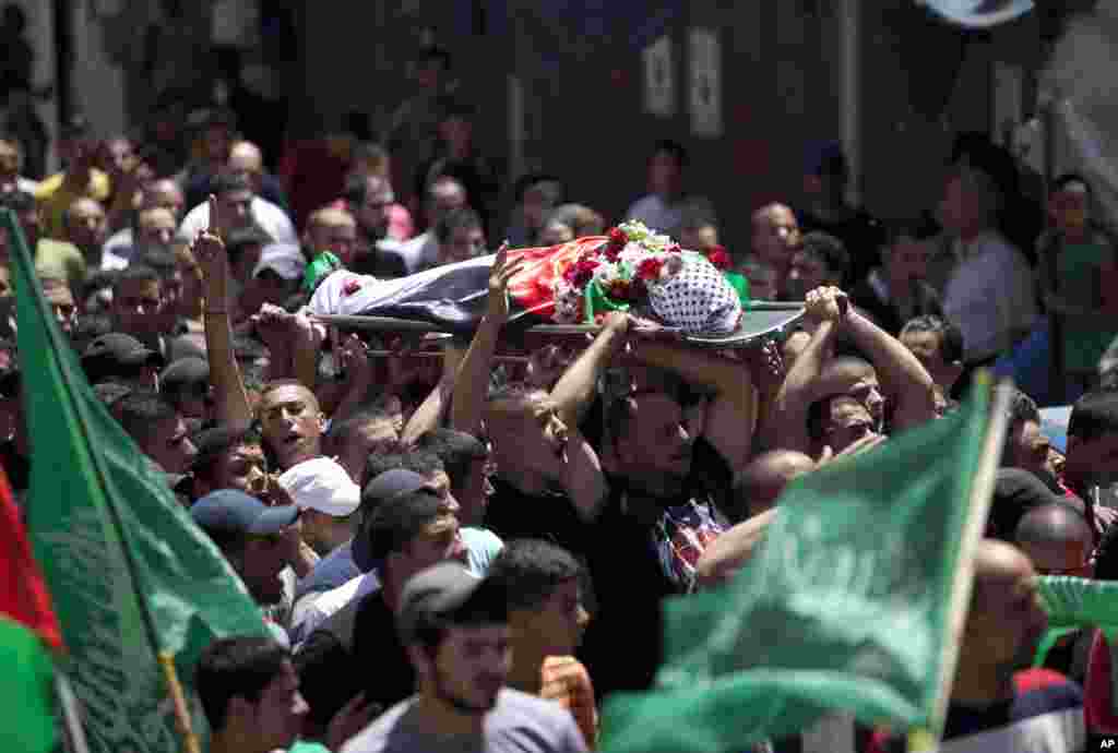 Palestinianos carregam o corpo de Mohammed al-Araj, no seu funeral no campo de refugiados de&nbsp; em West Bank, cidade de Ramallah, Julho 25, 2014.