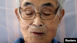 Katsuo Saito, 89, yang menderita leukemia, menggunakan selang oksigen pada saat beristirahat di rumahnya di Tokyo, Jepang, 8 September 2017. 