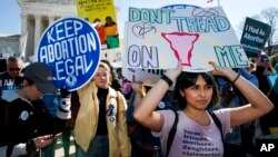 FILE - Abortion rights demonstrators including Jaylene Solache, of Dallas, Texas, right, rally, Wednesday, March 4, 2020, outside the Supreme Court in Washington. (AP Photo/Jacquelyn Martin)