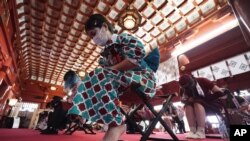 Employees dressed in maid costumes from several maid-themed cafes of Akihabara attend a prayer meeting and pray for protection from COVID-19 and for a thriving business at the Kanda Myojin shrine July 25, 2020, in Tokyo. 