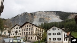 FILE - Residential buildings stand in front of the Brienzer Rutsch, the rockfall danger zone in Brienz-Brinzauls, Switzerland, May 12, 2023. 