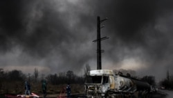 8일(현지시간) 이란 테헤란의 샤한 연료 탱크가 공격을 받아 파괴된 차량 뒤로 검은 연기가 솟구치고 있다. [사진 제공: 마지드 아스가리푸르/WANA 통신/로이터] 