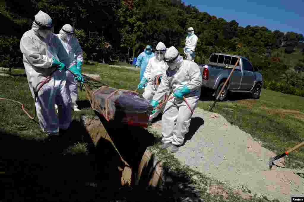 En El Salvador, trabajadores entierran el ata&#250;d de un hombre, que muri&#243; de COVID-19, en el Cementerio Jard&#237;n, mientras contin&#250;a el brote de COVID-19, en Soyapango.