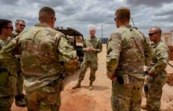 FILE - U.S. Army Brig. Gen. Damian T. Donahoe, deputy commanding general, Combined Joint Task Force-Horn of Africa, center, talks with service members during a battlefield circulation, Sept. 5, 2020, in Somalia.