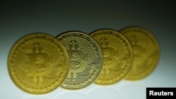 FILE - Mock Bitcoins are displayed on a table in an illustration picture taken in Berlin, Jan. 7, 2014.