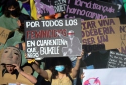 Mujeres sostienen pancartas mientras participan en una marcha exigiendo el fin de la violencia contra las mujeres y el feminicidio en el país, antes de una protesta por el Día Internacional de la Mujer, en San Salvador, el 7 de marzo de 2021.