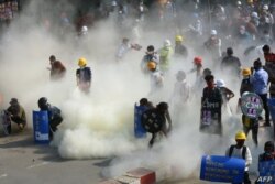 Los manifestantes reaccionan después de que la policía lanzara gases lacrimógenos durante una manifestación contra el golpe militar en la ciudad noroccidental de Kalay, el 2 de marzo de 2021.