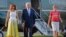 FILE - President Donald Trump, first lady Melania Trump and son Barron Trump walk across the tarmac to board Air Force One at Morristown Municipal Airport, Aug. 20, 2017, in Morristown, N.J.