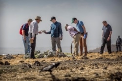 FILE - Foreign investigators examine wreckage at the scene where the Ethiopian Airlines Boeing 737 Max 8 crashed shortly after takeoff killing all 157 on board, near Bishoftu, or Debre Zeit, south of Addis Ababa, March 12, 2019.