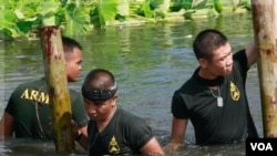 Tentara Thailand memperbaiki pembatas air yang rusak dihantam banjir di Bangkok, Minggu (30/10).