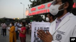 Doctors pay tribute to Indian soldiers killed during a confrontation with Chinese soldiers in the Ladakh region, while holding their photos, in New Delhi, India, June 18, 2020. 