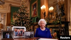 Britain's Queen Elizabeth poses, after recording her annual Christmas Day message in Windsor Castle, in Berkshire, Britain, in this undated pool picture released on Dec. 24, 2019. 