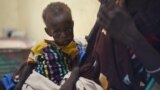 FILE - Nyagoah Taka Gatluak, a severely malnourished one-year-old child, sits on her mother's lap in the Doctors Without Borders clinic in Leer town, South Sudan.