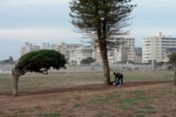 A homeless man stands with some of his belongings at the usually popular and busy Promenade, which is now mostly deserted because of the lockdown in South Africa, caused by the COVID19 pandemic, on April 23, 2020, in Cape Town.