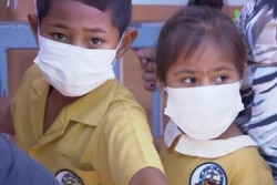 FILE - Children, their faces covered with masks, wait to get vaccinated against measles at a health clinic in Apia, Samoa, Nov. 18, 2019.