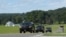 Official vehicles drive down a road near Camp David, Md., Aug. 18, 2017.