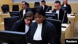 Prosecutor of the International Criminal Court Fatou Bensouda (R) and senior trial lawyer Eric MacDonald are seen at the confirmation of charges hearing in Laurent Gbagbo's pretrial at the ICC in The Hague, February 19, 2013.