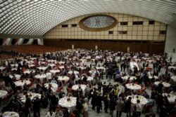 People wait for Pope Francis arrival for a lunch in the Paul VI Hall at the Vatican, Nov. 17, 2019.