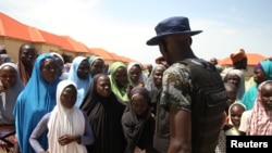 Un policier discute avec des déplacés au camp de Bakkasi, à Maiduguri, dans l'État de Borno, Nigeria, 29 août 2016.