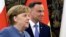 German Chancellor Angela Merkel, left, and Polish President Andrzej Duda walk for talks on European Union future and security and on bilateral ties, at the Belvedere Palace in Warsaw, Poland, March 19, 2018. 