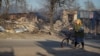 Una residente local camina con una bicicleta, en el lugar de los ataques aéreos rusos, en medio del ataque de Rusia a Ucrania, en la aldea de Lyptsi, región de Járkov, Ucrania, el 10 de abril de 2024.