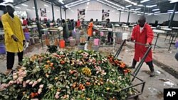 Workers push cart loaded with discarded fresh roses at a flower exporter's farm in Naivasha, 19 Apr 2010
