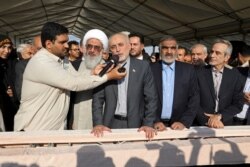In this photo by the Atomic Energy Organization of Iran, Ali Akbar Salehi, head of the organization, orders pouring concrete for the base of the second nuclear power reactor at Bushehr plant, Nov. 10, 2019.