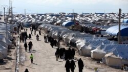 FILE - Women walk through al-Hol displacement camp in Hasaka governorate, Syria, April 1, 2019. There has long been worry about a potential coronavirus outbreak in northeastern Syria, home to several displaced-person and refugee camps.