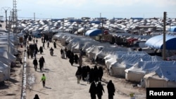 FILE - People walk through al-Hol displacement camp in Hasaka governorate, Syria, April 1, 2019. Northeastern Syria is home to several displaced-person and refugee camps.