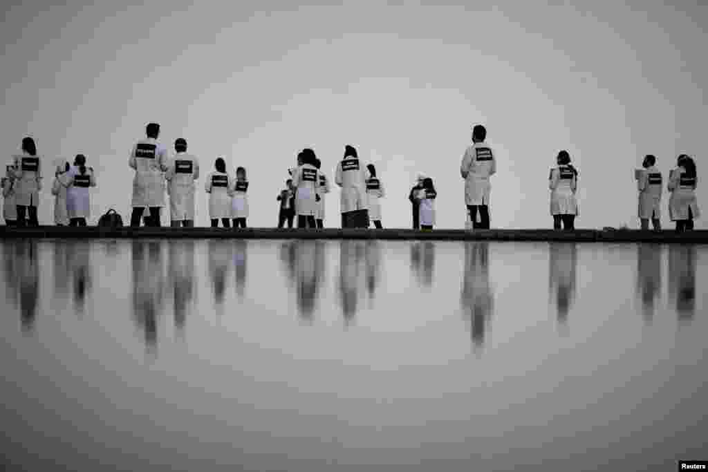 Nurses wearing protective face masks participate in a protest with signs bearing the names of health care professionals who died from the coronavirus, in Brasilia, Brazil, May 12, 2020.