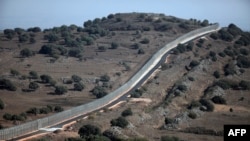 FILE - A picture taken from the Israeli-occupied Golan Heights on Aug. 30, 2014 shows the Israeli border with Syria near the Quneitra crossing, the only border crossing between Israel and Syria. 