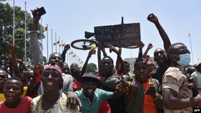 FILE - People celebrate as the Guinean Special Forces arrive at the Palace of the People in Conakry, Sept. 6, 2021.
