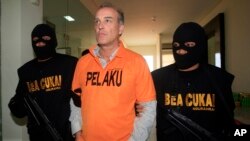 Warga Jerman Hans Peter Naumann dikawal petugas bea cukai di Bali (27/9). (AP/Firdia Lisnawati)