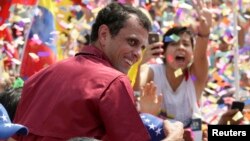 Calon Presiden oposisi Henrique Capriles (baju merah) melakukan kampanye di Caracas di hadapan puluhan ribu pendukungnya, Minggu (7/4).