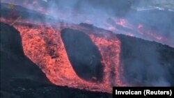 Aliran lava tampak mengalir di laguna dekat gunung berapi di La Palma, Kepulauan Canary, Spanyol, pada 22 November 2021 dalam potongan gambar yang didapat dari video yang beredar di media sosial. (Foto: Involcan via Reuters)