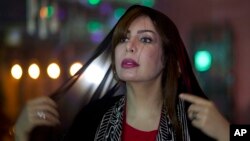 Women's rights activist Souad al-Shammary puts on a head scarf in Jiddah, Saudi Arabia, May 7, 2016.