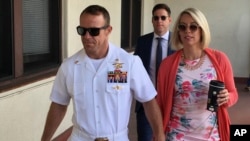 FILE - Navy Special Operations Chief Edward Gallagher, left, walks with his wife, Andrea Gallagher, as they arrive at military court on Naval Base San Diego, July 1, 2019, in San Diego.