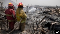 Los bomberos trabajan para controlar un incendio que destruyó cientos de viviendas en la barriada de Cantagallo, en Lima, Perú, el viernes 4 de noviembre de 2016.