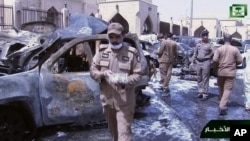 In this image from Saudi TV video, investigators collect evidence in the aftermath of a suicide bombing outside the Imam Hussein mosque in Dammam, Saudi Arabia, May 29, 2015.