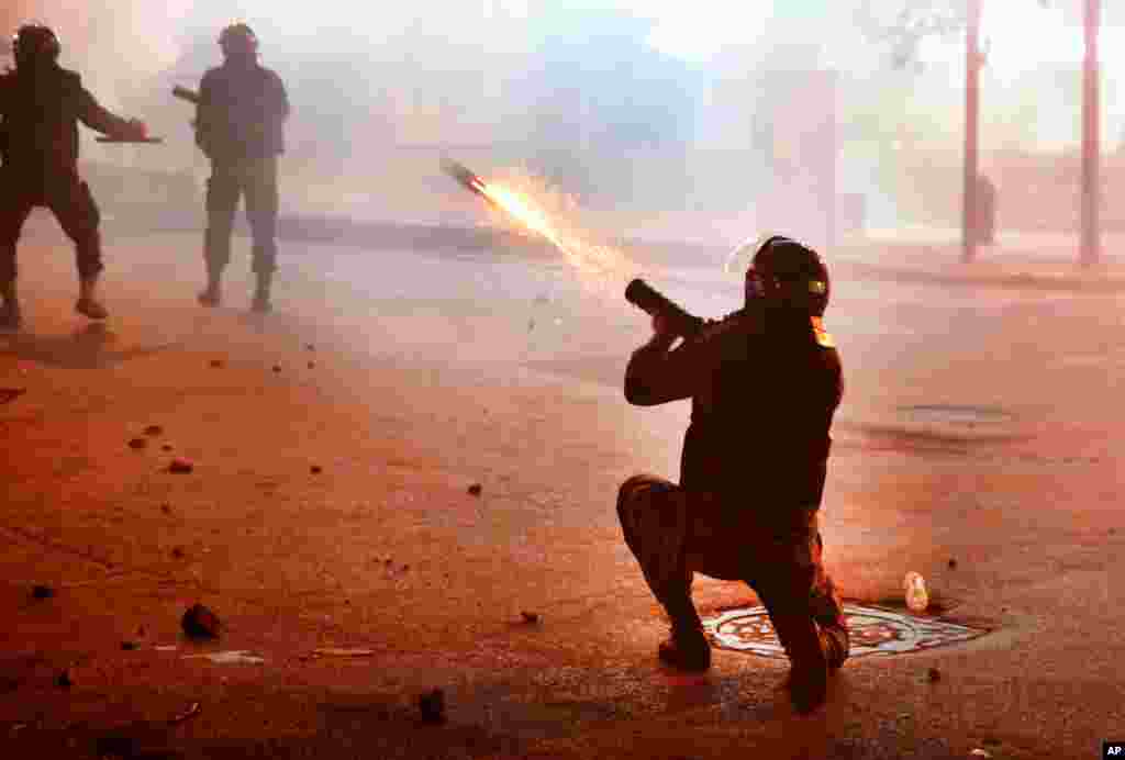 A riot policeman fires tear gas at anti-government protesters, during ongoing demonstrations against the Lebanese central bank&#39;s governor and the deepening financial crisis, at Hamra Trade Street, in Beirut, Lebanon, Jan. 14, 2020