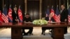 U.S. President Donald Trump and North Korea's leader Kim Jong Un sign documents that acknowledge the progress of the talks and pledge to keep momentum going, after their summit at the Capella Hotel on Sentosa island in Singapore, June 12, 2018. 