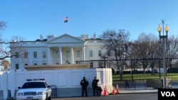 U.S. Secret Service officers stand guard as construction crews work on renovations to the perimeter fence on the North Lawn of the White House, February 27, 2020. (Saqib Ul Islam/VOA)