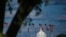 FILE - The dome of the U.S. Capitol building is seen behind a row of U.S. flags in Washington, April 10, 2020.