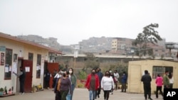 ARCHIVO - La gente llega a una escuela pública que funciona como centro de votación durante una elección de alcalde, en Lima, Perú, el domingo 2 de octubre de 2022.