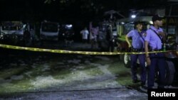 FILE - Officers stand behind a police line after a man was killed during an anti-drug operation in Caloocan city, Metro Manila, Philippines, Aug. 17, 2017.