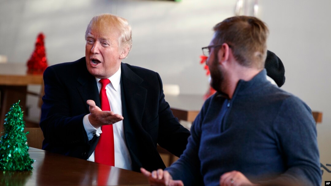 President Donald Trump meets retired U.S. Marine Corps Sgt. John Peck and his wife, Jessica, as Trump visits with wounded service members and their families at Walter Reed National Military Medical Center, Dec. 21, 2017, in Bethesda, Md. 
