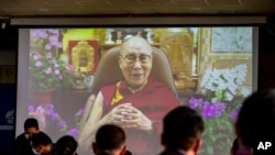 Exile Tibetan government officials watch a message from their spiritual leader the Dalai Lama on a screen during a ceremony to mark the 86th birthday of the Tibetan leader in Dharmsala, India, July 6, 2021.