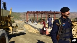 In this Dec. 22, 2017, photo, a Pakistani police officer stands guard at the site of Pakistan China Silk Road in Haripur, Pakistan. From Pakistan to Tanzania to Hungary, projects under Chinese President Xi Jinping's signature "Belt and Road Initiative" are being canceled, renegotiated or delayed. (AP Photo/Aqeel Ahmed)