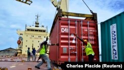 Des ouvriers déplacent un conteneur de riz dans le port de Cotonou, au Bénin, le 13 octobre 2014. 