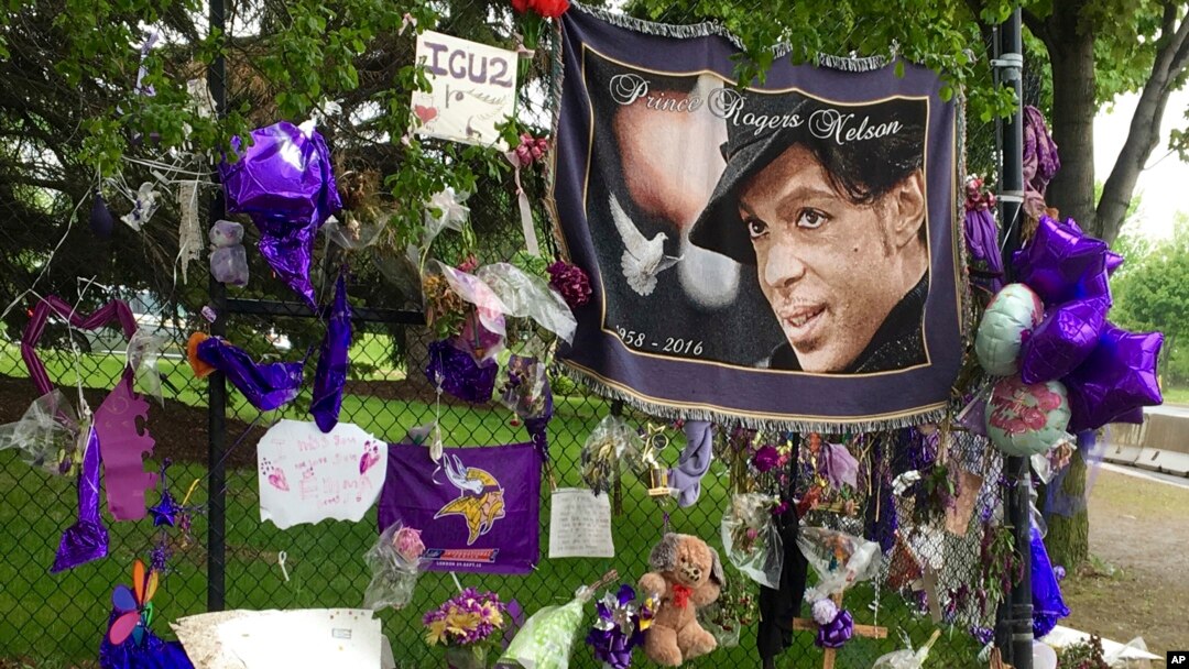FILE - Items left by fans at a memorial for Prince hang from a fence outside the musician's Paisley Park estate in Chanhassen, Minnesota, May 11, 2016. 